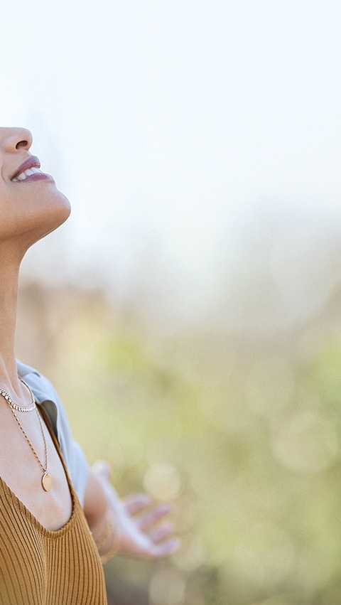 Young woman with arms outstretched breathing in.